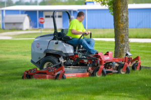 Landscaping employee mowing grass of a commercial property