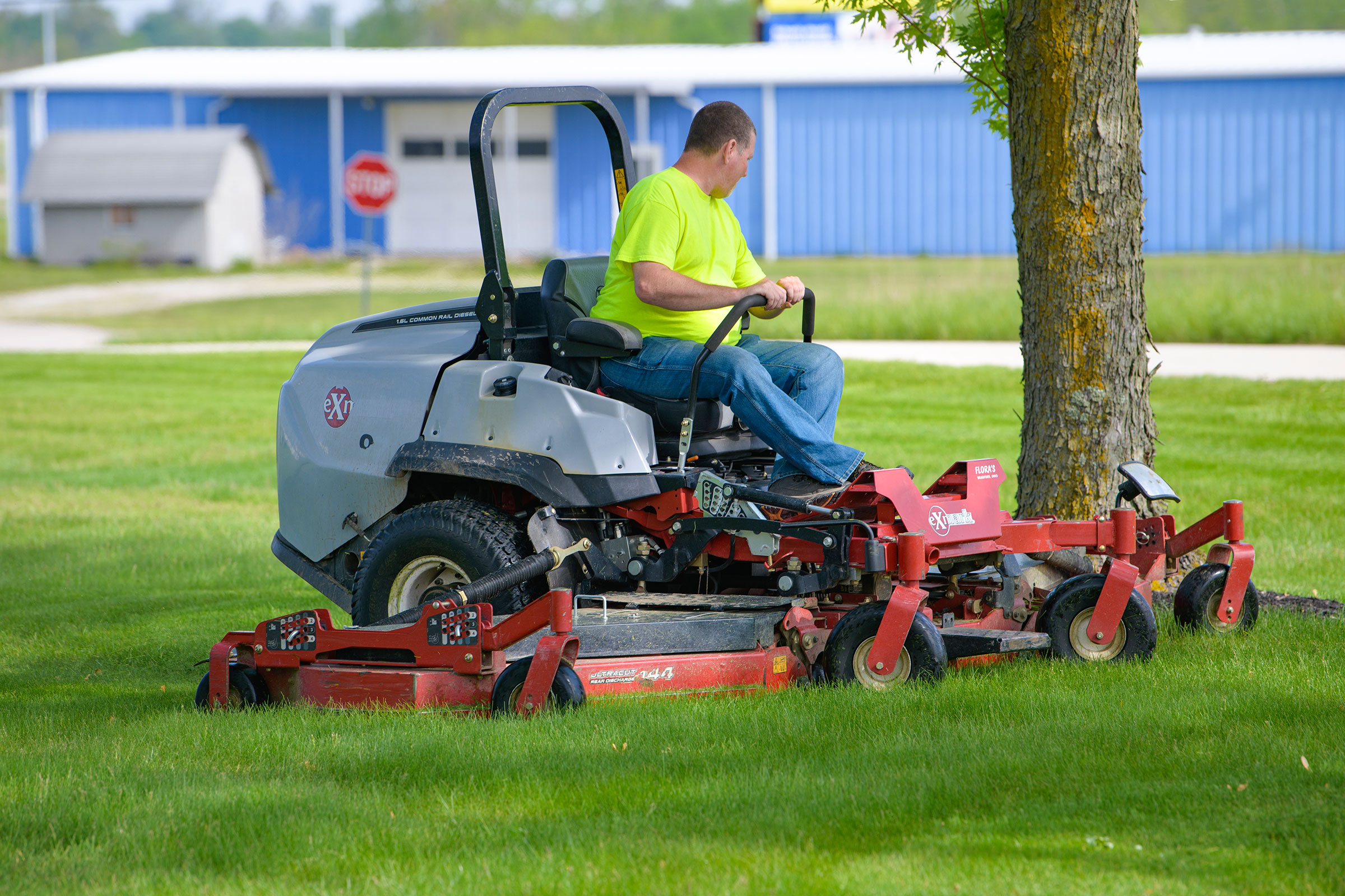 Landscaping employee mowing grass of a commercial property