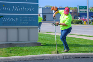 a landscaper edging an area near a commercial sign